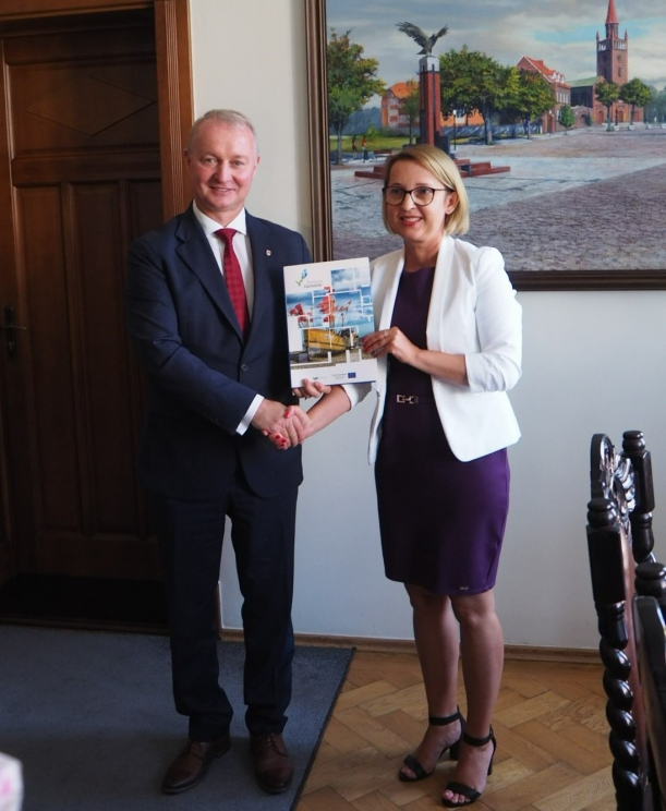 Sygnatariusze umowy prezentują podpisany dokument.