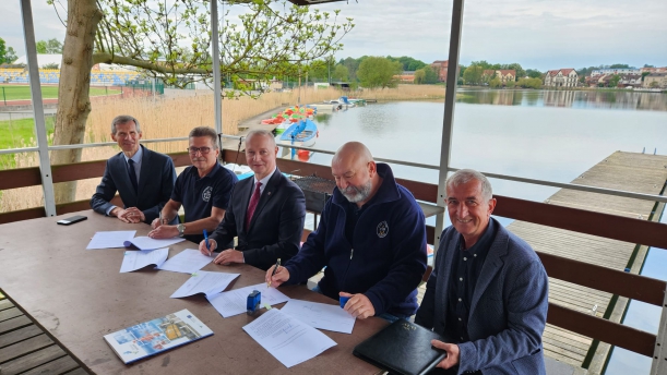 Komandor i skarbnik klubu podpisują umowę z wicemarszałkiem Olgierdem Kustoszem na przystani żeglarskiej w Barlinku