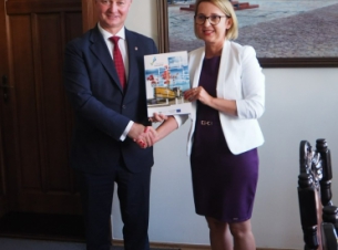 Sygnatariusze umowy prezentują podpisany dokument.