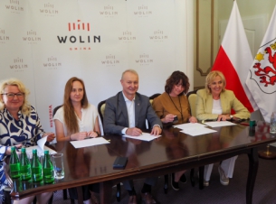 Podpisanie umów dla Gminy Wolin. Z beneficjentami, za stołem siedzi wicemarszałek Olgierd kustosz (II od lewej). Są podpisywane umowy 