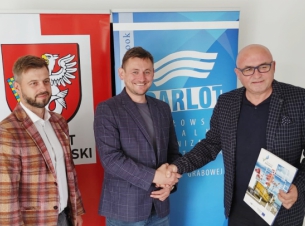 trzech  mężczyzn  na tle kolorowych bannerów 