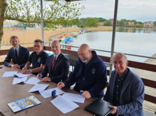 Komandor i skarbnik klubu podpisują umowę z wicemarszałkiem Olgierdem Kustoszem na przystani żeglarskiej w Barlinku
